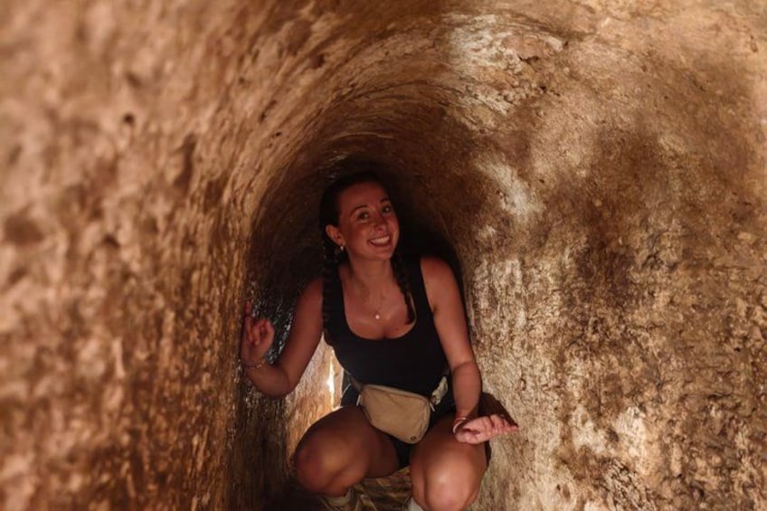 Eine Person sitzt in einem schmalen, felsigen Tunnel. 3