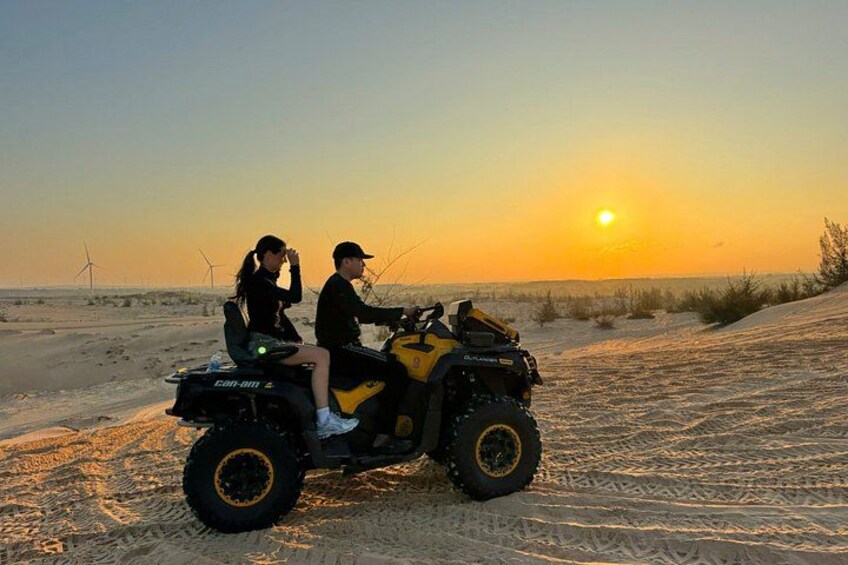 Dos personas en un vehículo todo terreno amarillo en el desierto al atardecer. 5