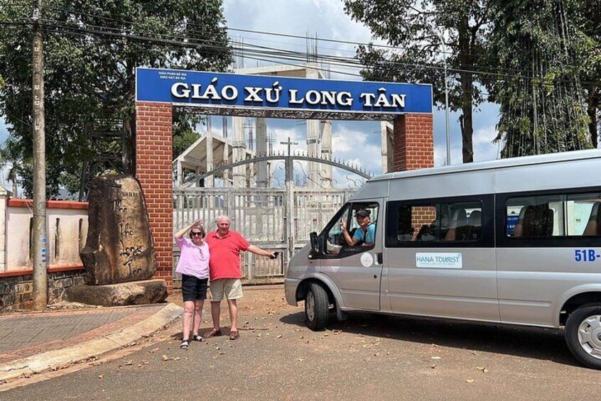 A bus labeled 'HANA TOURIST' at a gate with a sign reading 'GIÃO XÚ LONG TÂN'. 2