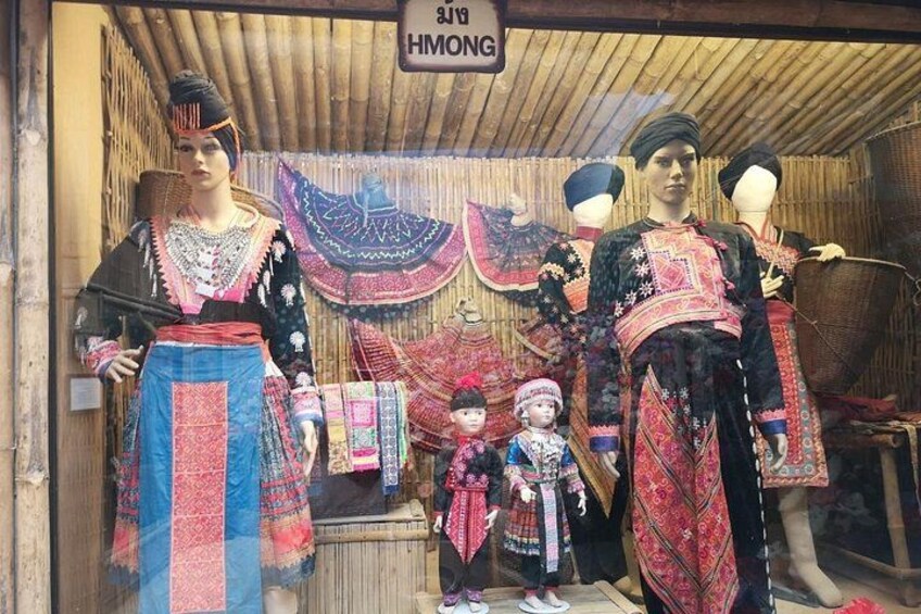 Mannequins dressed in traditional attire, a sign reading 'HMONG', and a bamboo structure. 5
