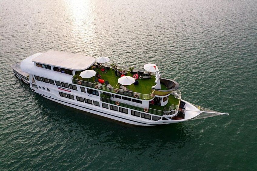 A large white river cruise ship with a deck area featuring outdoor seating and a small garden. 1