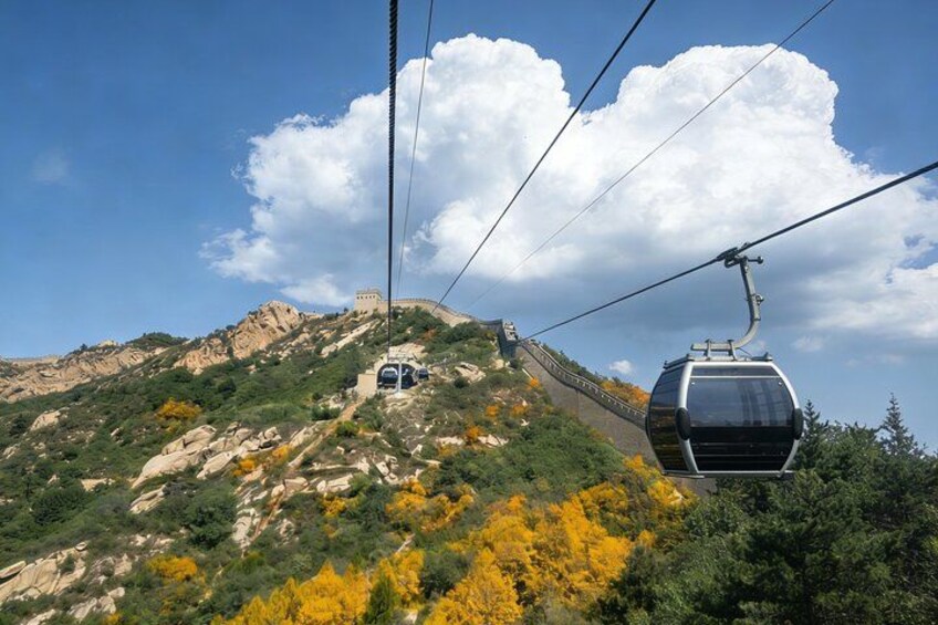 Un teleférico asciende una montaña con cielo despejado y follaje otoñal. 3