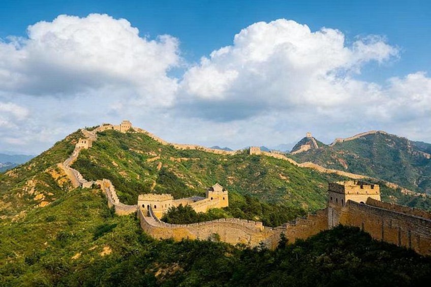 Die Chinesische Mauer schlängelt sich durch grüne Hügel unter blauem Himmel. 3
