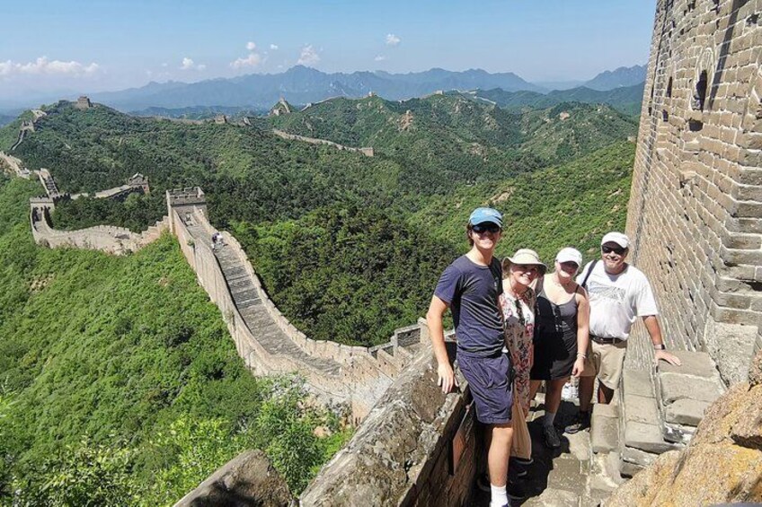 Un grupo de personas está de pie en la Gran Muralla China, con un paisaje montañoso al fondo. 2