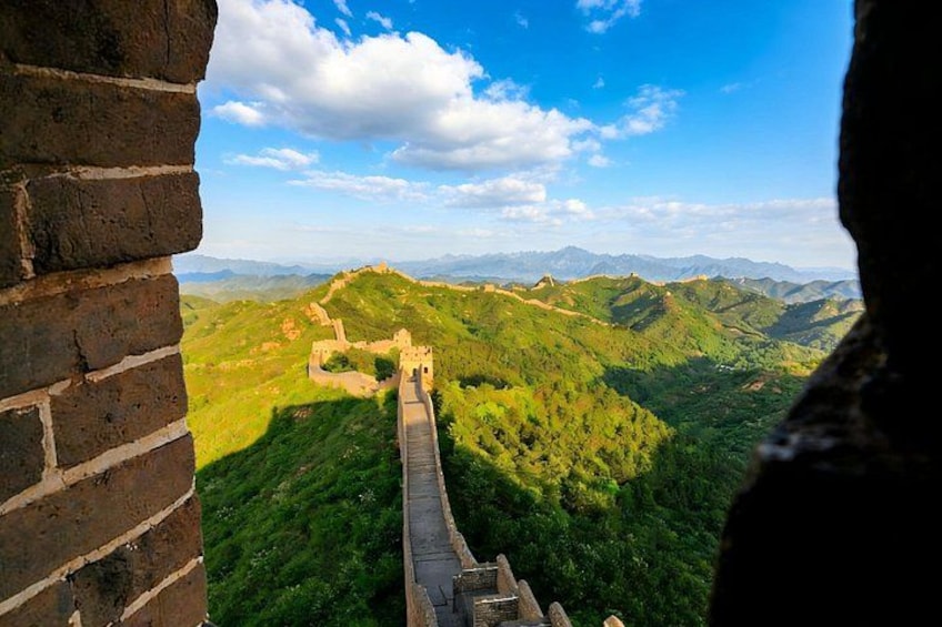 The Great Wall of China, lush green hills, and a clear blue sky. 4