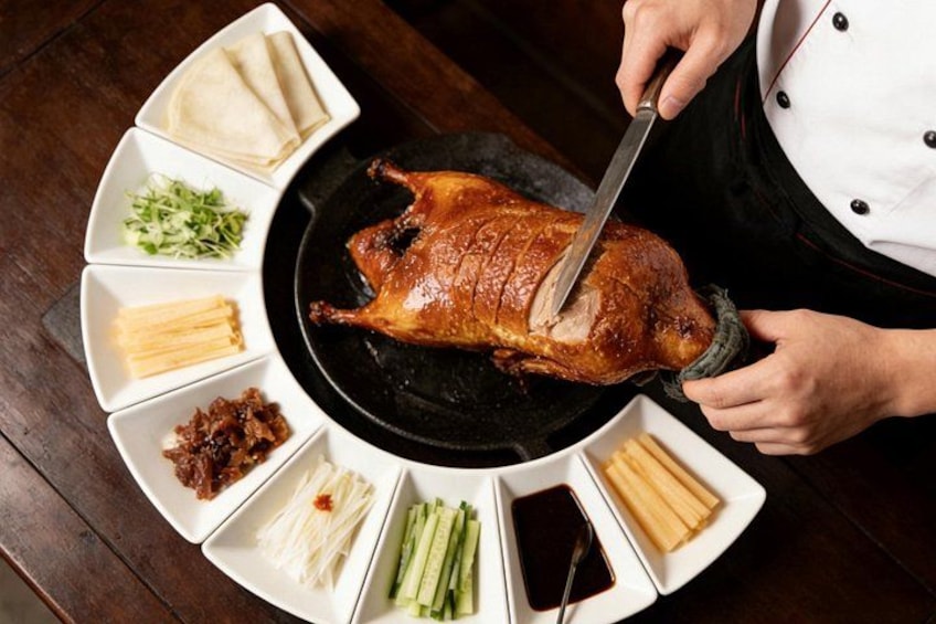A chef carving a roasted duck with a carving fork. 2