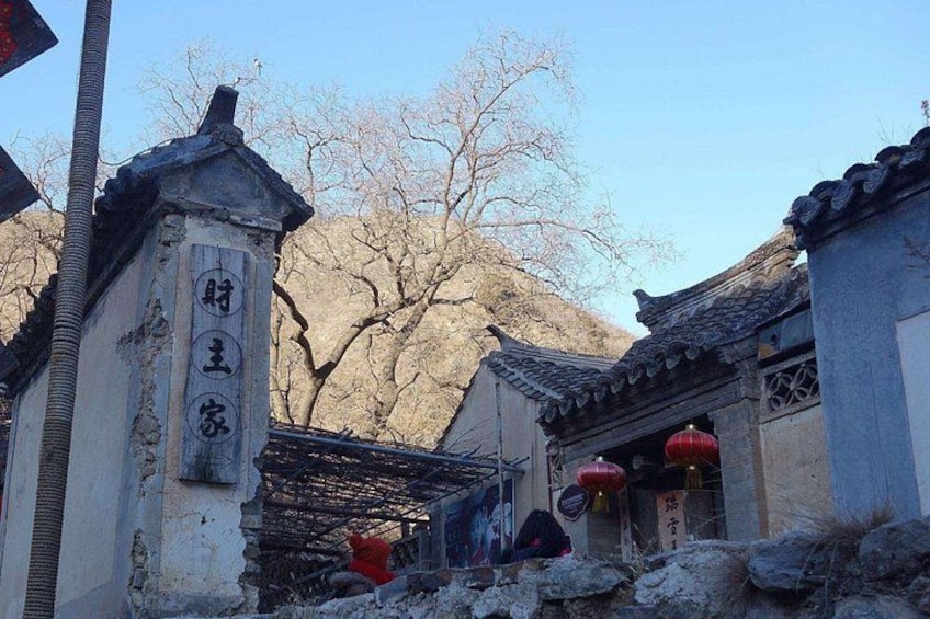 Traditional Chinese architecture with a stone pillar, a tiled roof, and a red lantern. 4