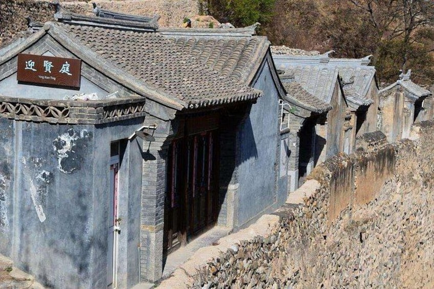 Traditional Chinese architecture with tiled roofs and a signboard. 3