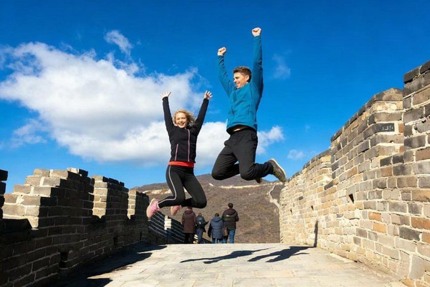 Dos personas saltando frente a la Gran Muralla China. 1
