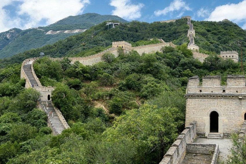 La Gran Muralla China serpenteando a través de un paisaje montañoso con abundante vegetación. 2