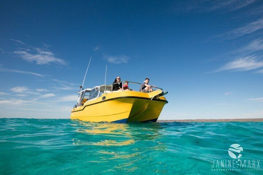 Un bote amarillo con tres personas en el agua. 1