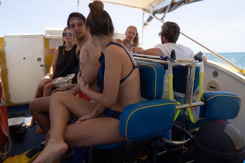 Mensen in een boot met blauwe stoelen en een reddingsvest op de vloer. 5