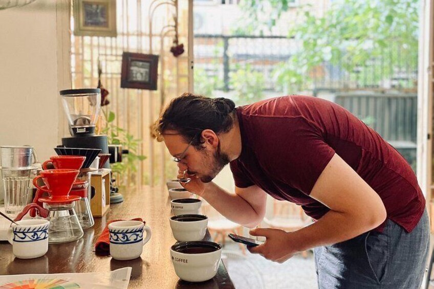 Una persona presso una postazione con caffettiere e tazze. 5
