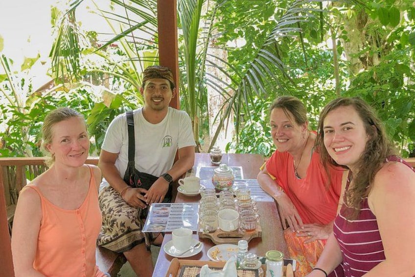 A group of people sitting at an outdoor table with various food items and drinks. 4