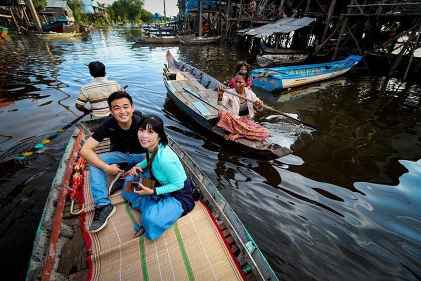 Des personnes se trouvent sur une voie navigable étroite, à bord d’un bateau traditionnel, entourées de structures en bois. 2