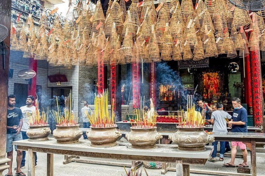 Incense burners, a temple interior, and people. 4