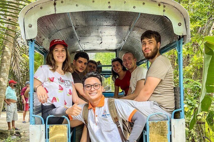 A group of people in a vehicle surrounded by greenery. 3