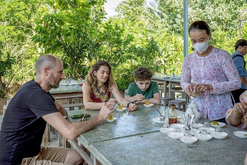 Personas comiendo al aire libre en una mesa con platos, vasos y cubiertos. 3