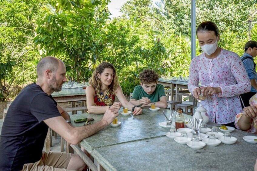 People dining outdoors at a table with food and drinks. 3
