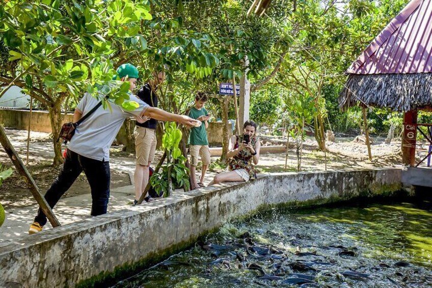 People near a water body with a thatched-roof structure. 5