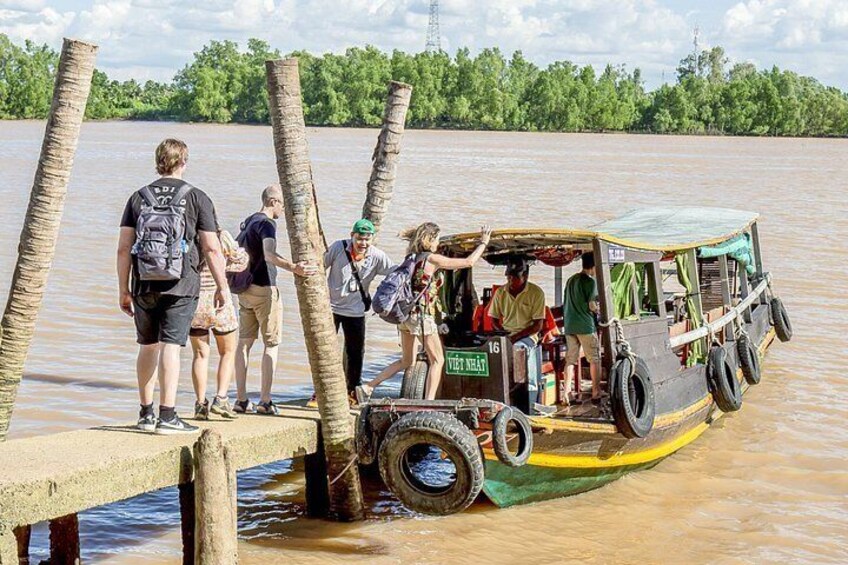 A boat with people boarding it at a wooden dock. 2