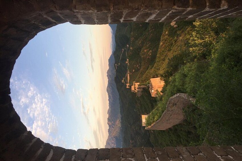 Un arco in pietra con vista su un paesaggio montuoso e edifici tradizionali. 5