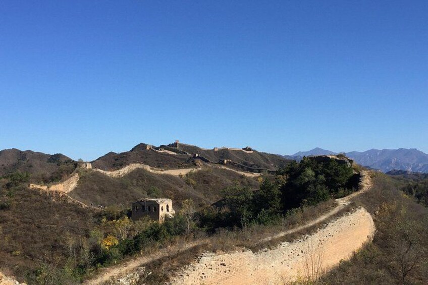Paisaje desértico con un camino de tierra, una torre de vigilancia y montañas al fondo. 2