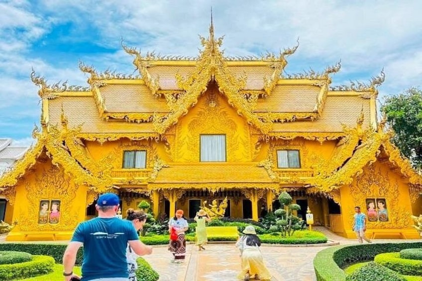 A golden temple with intricate architecture, a well-maintained garden, and a clear sky. 5