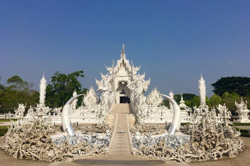 A white ornate temple with a central walkway leading to a shrine. 1