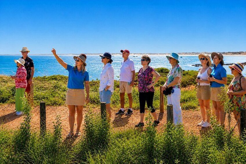 A group of people standing on a beach with the ocean in the background. 5