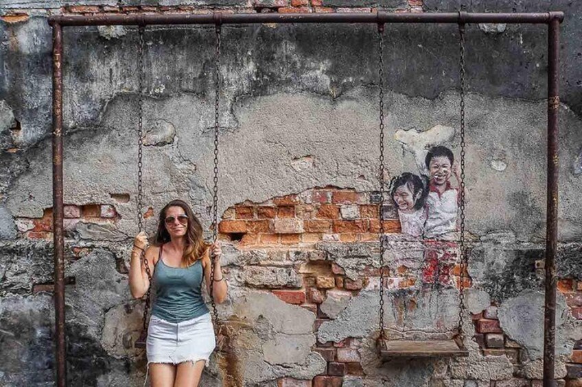Una donna sull'altalena di fronte a un murale. 2