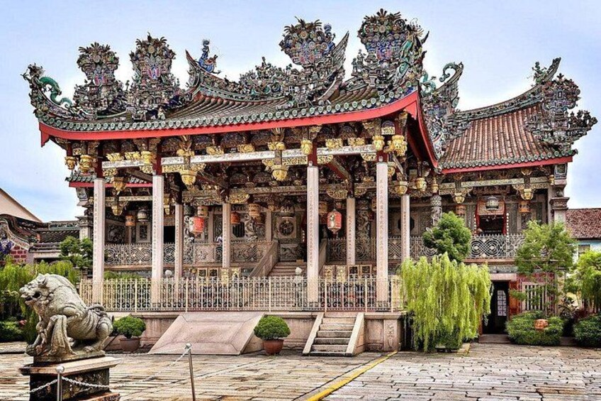 A traditional temple with ornate architecture, a statue, and a well-maintained garden. 5