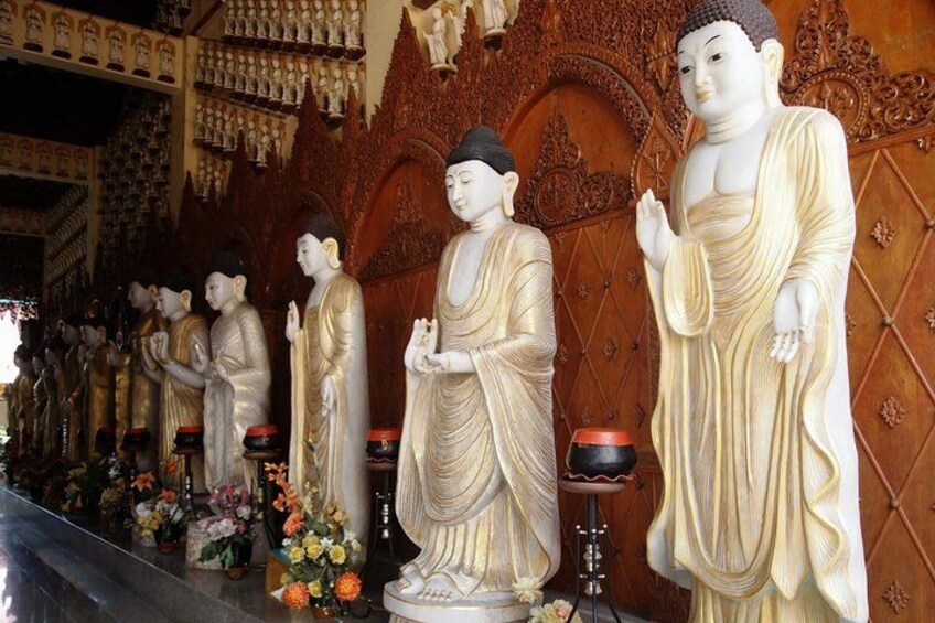 Een rij grote Boeddhabeelden in een tempel. 4