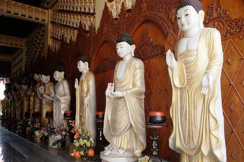 A row of golden Buddha statues in a temple. 3