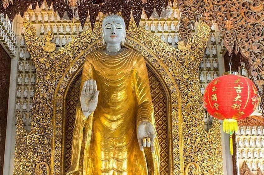 A large golden statue with intricate carvings, surrounded by ornate decorations and a red lantern. 4