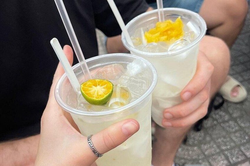 Two plastic cups with straws, containing a beverage and a slice of lime. 3