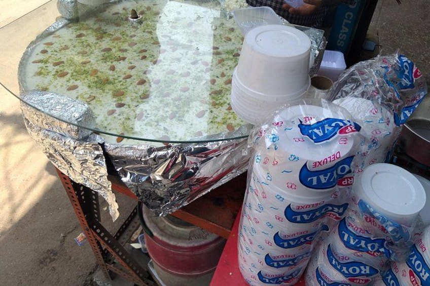 A glass table with foil wrapping, plastic cups, and paper towels. 1