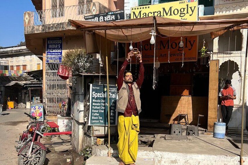 A street scene with a man standing in front of a shop named 'Macra Mogly.' 4