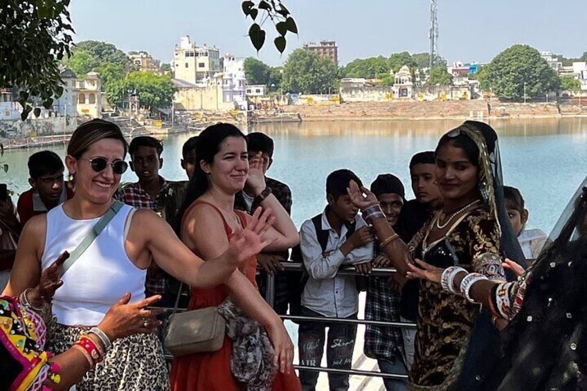 A group of people by a river with buildings in the background. 3