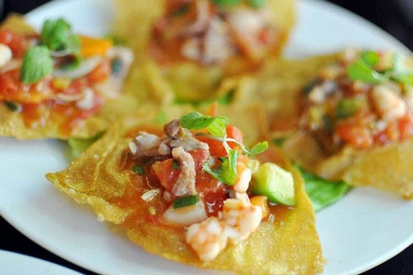 A plate with food items, including a shrimp topping and a green leafy vegetable. 4