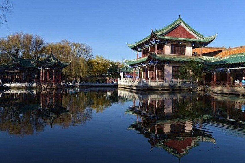 A traditional Chinese pavilion by a calm water body, reflecting the structure. 2