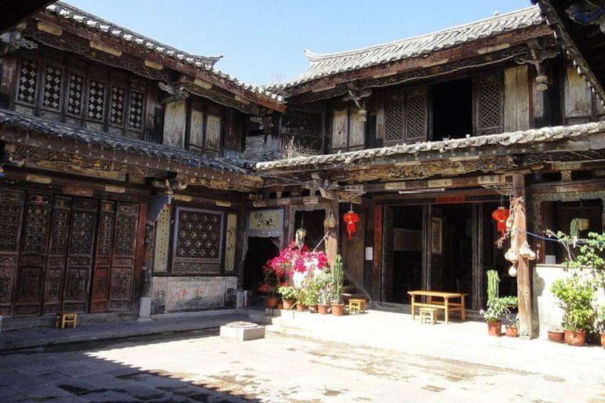 A traditional courtyard with wooden buildings, potted plants, and hanging decorations. 3