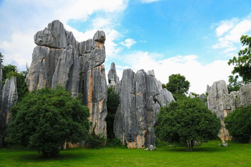 A landscape with tall rock formations and green trees. 2