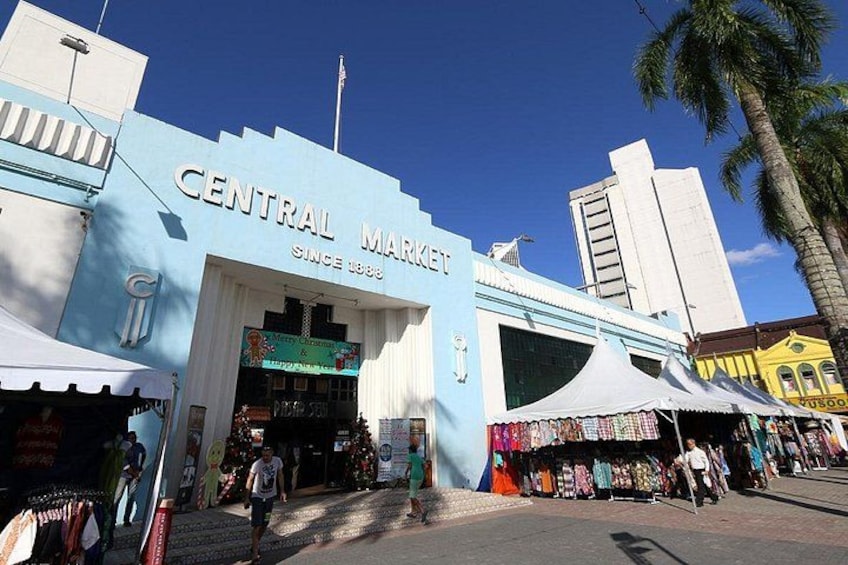 Central Market with a blue facade, palm trees, and various shops. 5