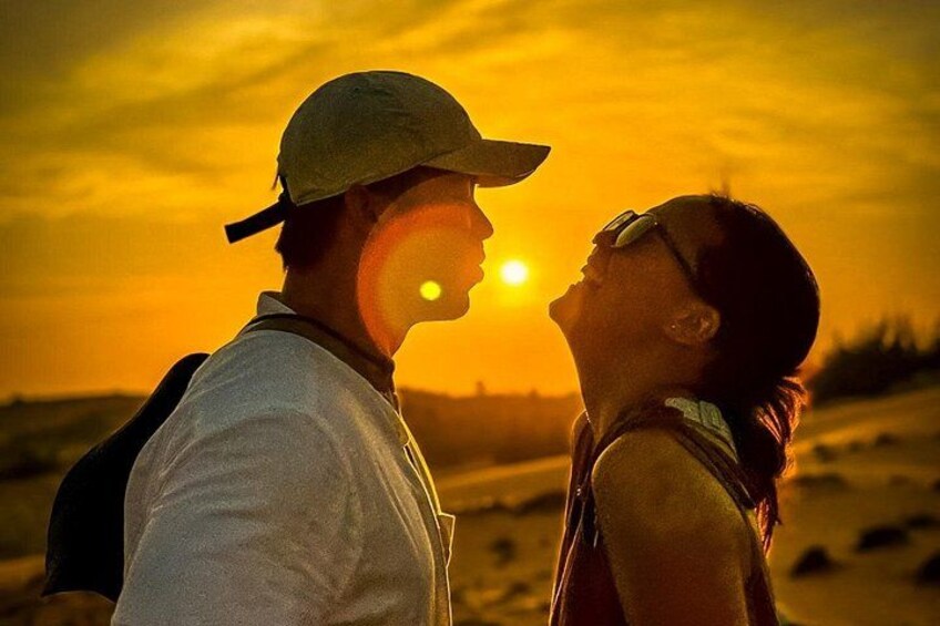 A couple standing on a beach during sunset. 3