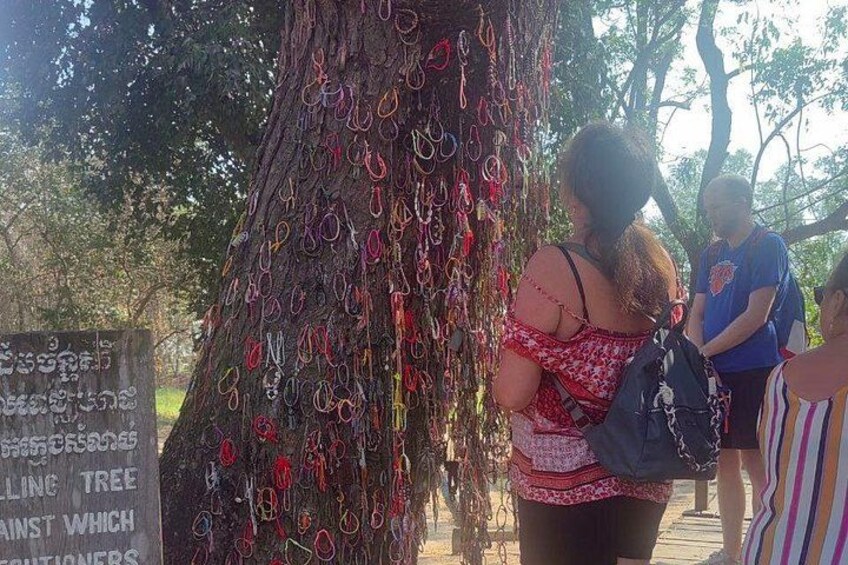 Un arbre orné de nombreuses bagues colorées et un panneau avec du texte dans une langue étrangère. 4