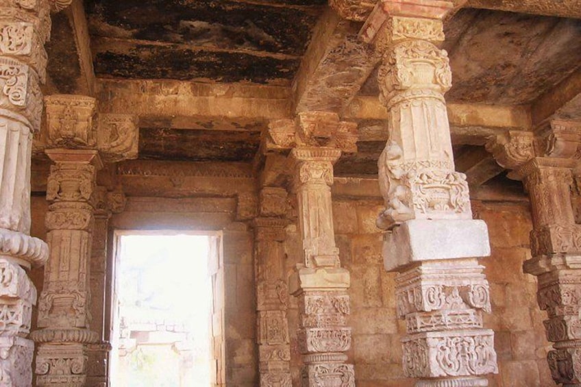 An ancient temple interior with detailed stone carvings and columns. 4