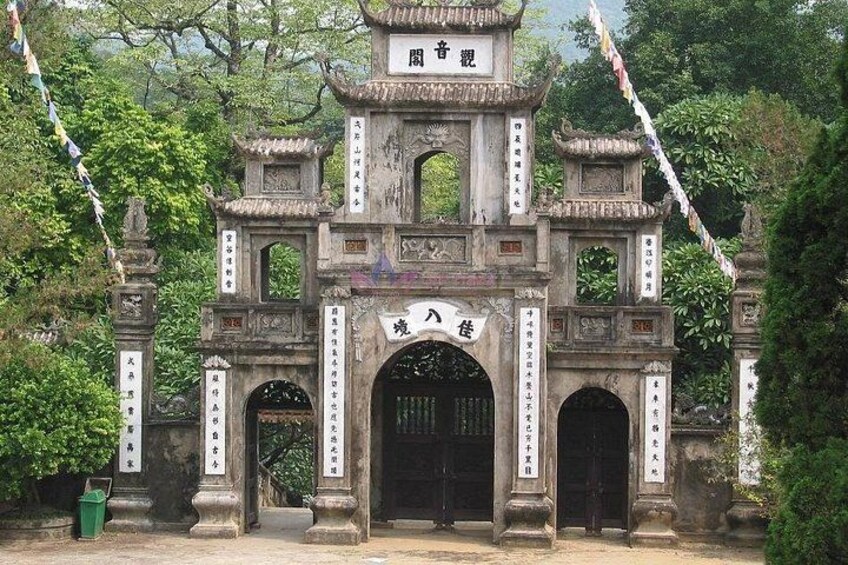A traditional Chinese gate with inscriptions, surrounded by lush greenery. 3