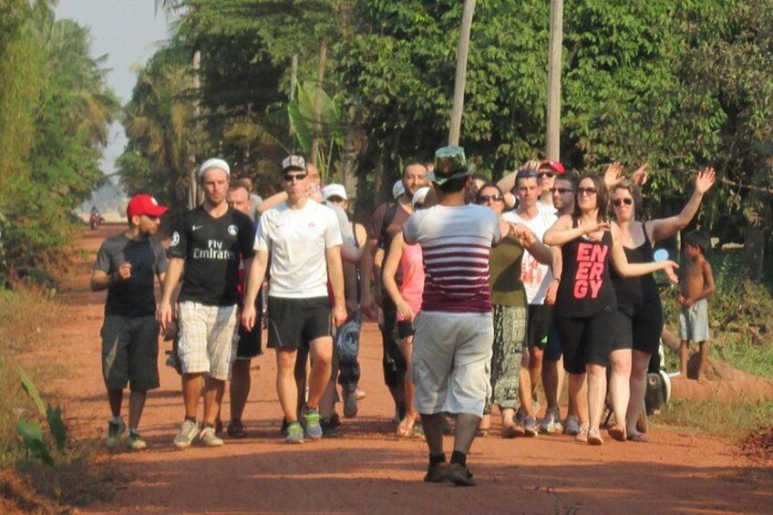 A group of people walking on a dirt path surrounded by trees. 5