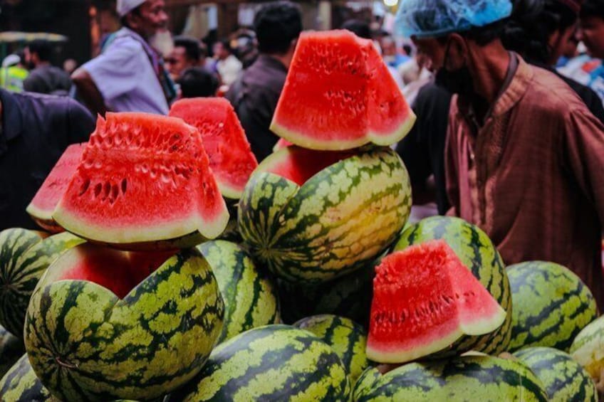 A market with watermelons and people. 2